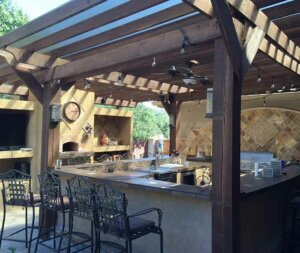 Outdoor kitchen with bar area and seating.