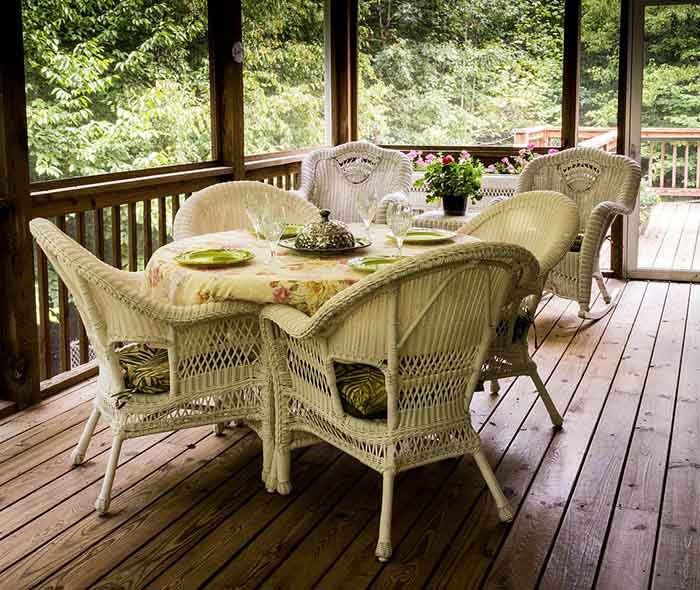 A screened porch with table and chairs.